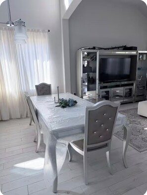 A dining area with a white table and chairs, a television, and a wardrobe. - Perfect private 1-bedroom shared house with AC in enjoyable Angleton (Angleton)