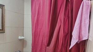 A bathroom with a white sink, a shower curtain, and a towel hanging on the wall. - Centrally located apartment, which allows your pet. (Mendoza)