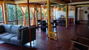 A spacious indoor area with a sofa, chairs, and a dining table.
