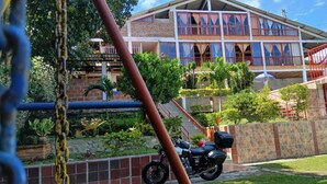 A multi-story building with balconies, a staircase, and a parked motorcycle.
