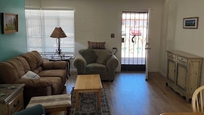 A living room with a sofa, armchair, coffee table, and a cabinet. - Charming apartment unit B ,  in beautiful Green Valley with cool AC breeze (Green Valley)