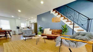 Un salon moderne avec un canapé, une table basse et un escalier.