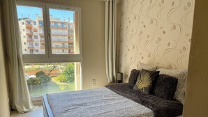 Ein Schlafzimmer mit einem Bett, einer Couch, einem Fenster und einer Wand mit Muster.