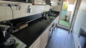 Eine moderne Küche mit schwarzem Arbeitsplatz, weißen Schränken und einem sichtbaren Mikrowellenherd.