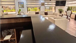 A modern living room with a long black table, beige sofas, a TV, and a large window with a view. - Village of Prague. Country house with swimming pool. (Pasto)