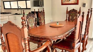 A dining room with a wooden table and chairs, a kitchen in the background, and a framed picture on the wall. - Village of Prague. Country house with swimming pool. (Pasto)