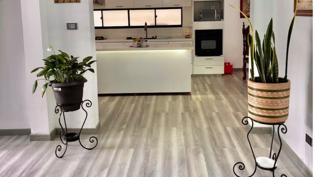 A modern kitchen with a central island, white cabinetry, and a dining area with a table and chairs. - Village of Prague. Country house with swimming pool. (Pasto)