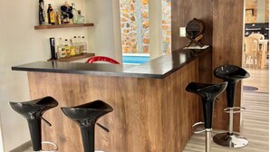 A modern bar area with wooden accents, bar stools, and shelves with bottles. - Village of Prague. Country house with swimming pool. (Pasto)