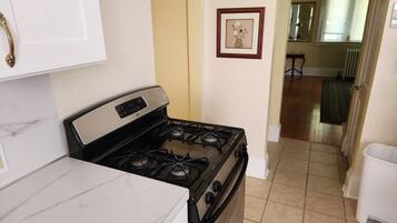 A kitchen with a stove, oven, and marble countertop.