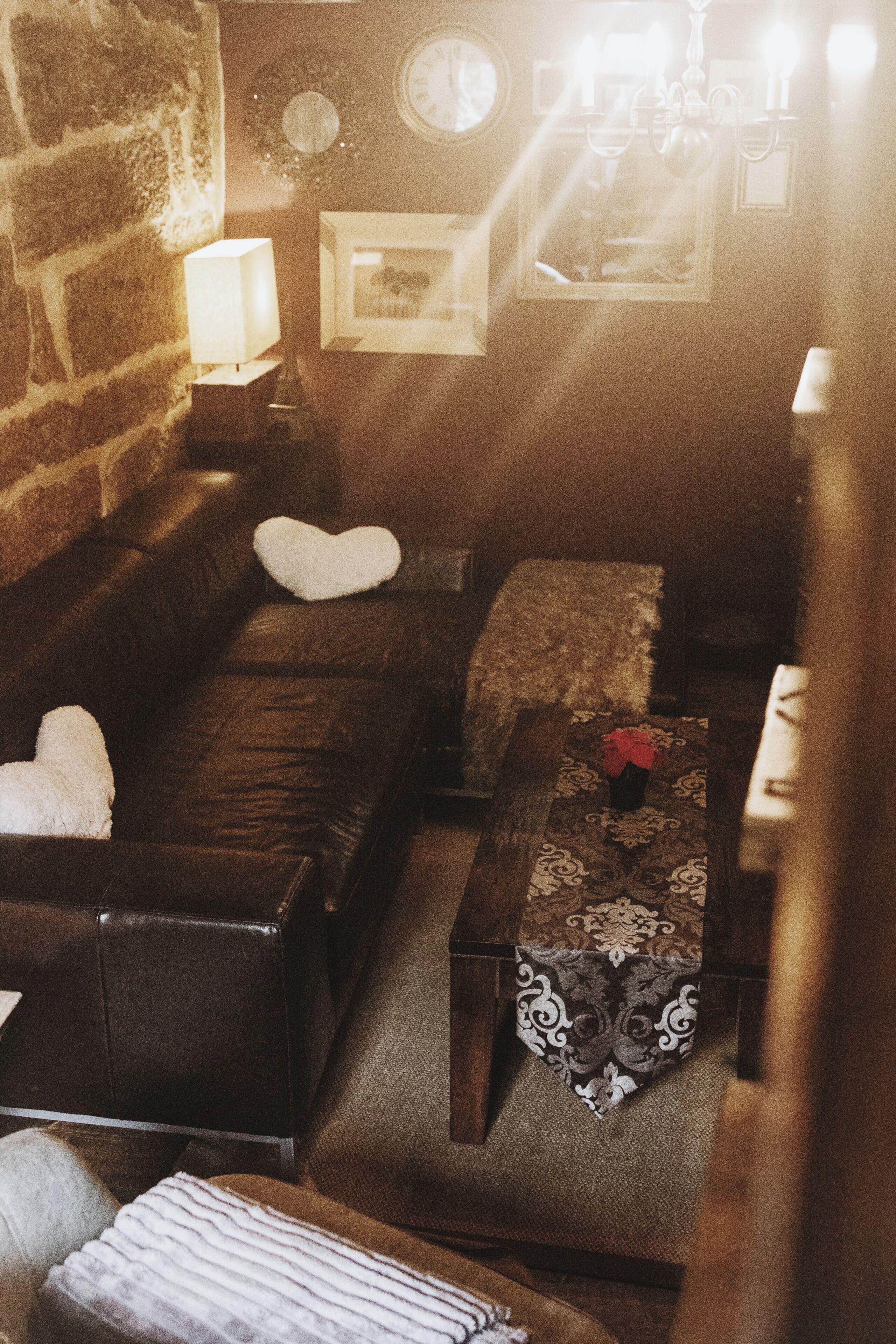 Una sala de estar acogedora con un sofá de cuero, una mesa de centro estampada y una chimenea.