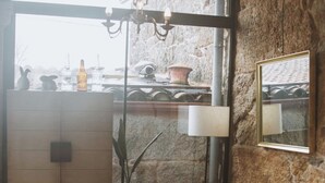 Une pièce confortable avec un canapé, une petite table, une lampe et une vue par la fenêtre.