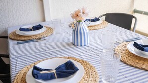Ett bord dukat med tallrikar, servetter, en vas och glas.