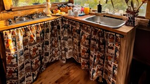 A kitchen with a wooden countertop, a sink, and a window with a view of trees.