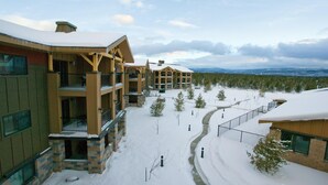 Eine mehrstöckige Lodge mit Balkonen und einer verschneiten Landschaft.