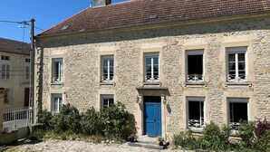 A stone building with a red-tiled roof, multiple windows, and a blue door. - La demeure aux Lilas a large stone mansion (Cirey-sur-Blaise)