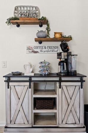 Una encimera de cocina con una cafetera, un hervidor y una taza.