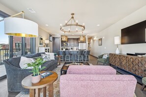 A modern living room with a sofa, a coffee table, and a dining area with a kitchen in the background. - Modern 2BR : Historic Lebanon • Sleeps 4 (Lebanon)