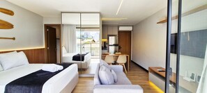 Ein Hotelzimmer mit Bett, Sofa, Schreibtisch und Blick auf die Stadt.