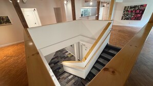 A modern interior with a wooden staircase, a patterned carpet, and a white door labeled 'RECEPTION.'