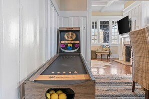 Une salle de bowling avec un plancher en bois, une zone de retour des boules et un panneau indiquant : « LANÇEZ ET FAITES GLISSER ».