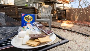Preparación para un picnic con una caja de galletas Honey Maid, malvaviscos, barras de chocolate y galletas Graham sobre una mesa de asador.