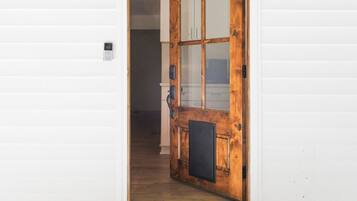 Une porte en bois avec un panneau de verre, une lanterne en métal et des fondations en briques.