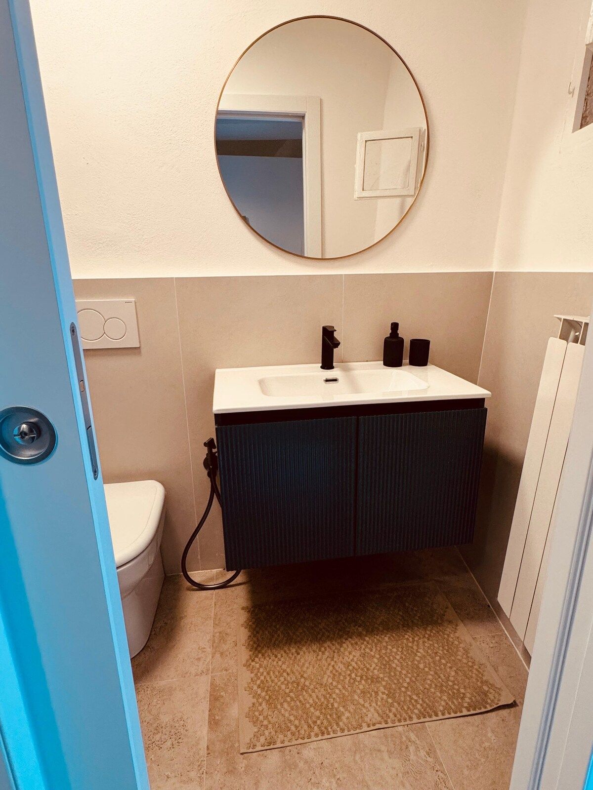 A bathroom with a toilet, sink, and mirror.