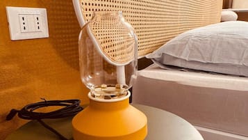 Ett rum med en säng, ett runt bord med en lampa och ett vägguttag.
