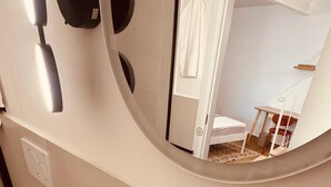 Une salle de bain avec un lavabo blanc, un miroir et un porte-serviettes.