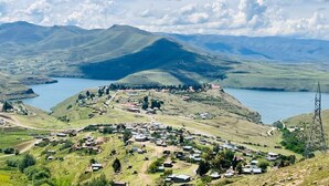 Un paisaje montañoso con un pequeño asentamiento y un lago.
