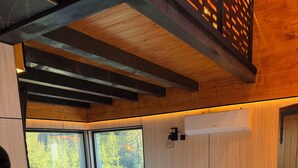 A modern bathroom with a large bathtub, wooden ceiling beams, and a window with a view of trees. - Srce Kamene Gore – peaceful mountain retreat with spa & nature. (Kamena Gora)