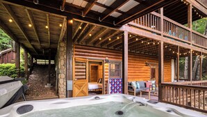 A log cabin with a hot tub, wooden deck, and a covered outdoor seating area. - Blue Bear Cabin | Views + Hot Tub + Sports Court (Blue Ridge)