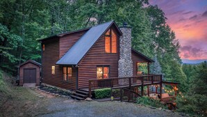 A log cabin with a stone chimney, a porch, and a small attached shed. - Blue Bear Cabin | Views + Hot Tub + Sports Court (Blue Ridge)