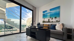 Ein modernes Wohnzimmer mit einer Couch, einem Couchtisch und einem Bild einer Strandlandschaft.