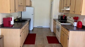 A compact kitchen with wooden cabinets, a refrigerator, a microwave, and a toaster. - Black Hills Gateway 

#CIMISC26-0010 (Rapid City)