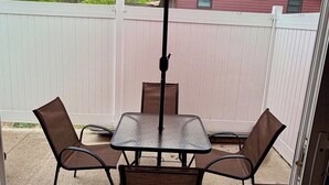 A patio with a table and four chairs, an umbrella, and a white fence in the background. - Black Hills Gateway 

#CIMISC26-0010 (Rapid City)