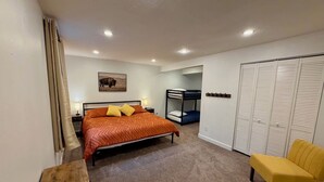 A bedroom with a bed, a bunk bed, a chair, a desk, and a wardrobe. - Black Hills Gateway 

#CIMISC26-0010 (Rapid City)