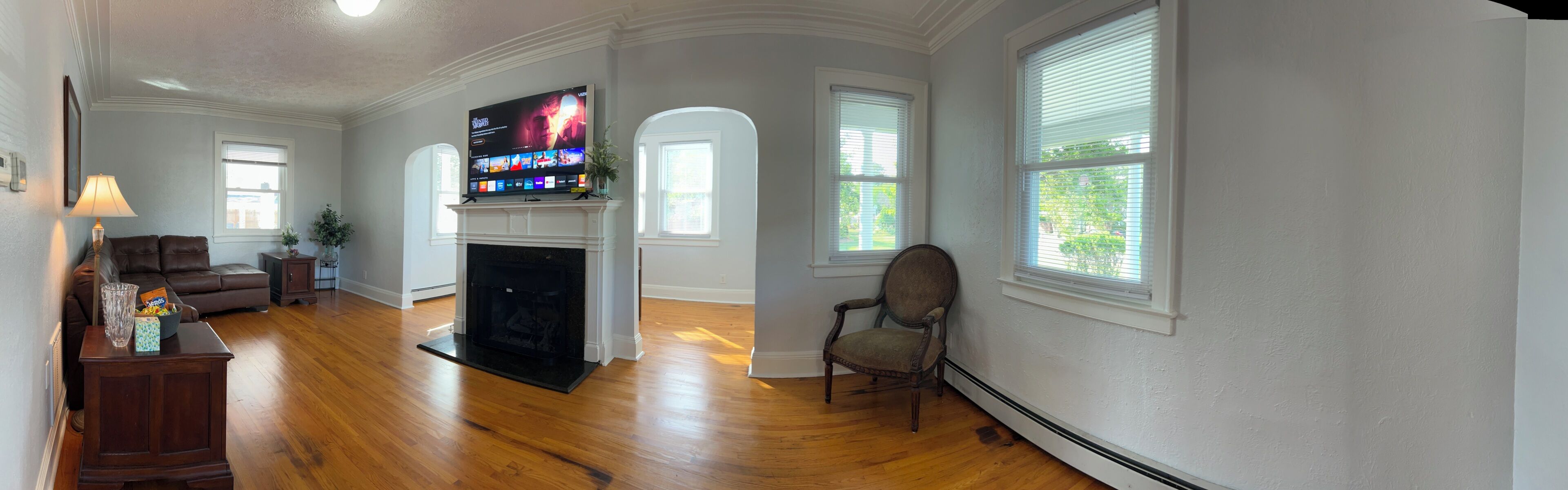 Ein Wohnzimmer mit Kamin, Fernseher und einer gemütlichen Sitzecke.