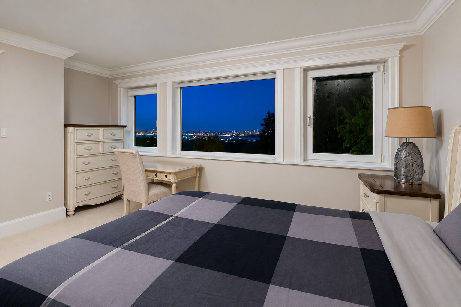 A bedroom with a bed, a desk, a chair, a dresser, a nightstand, and a lamp.