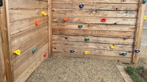 A wooden climbing wall with various colored holds. - Cozy 2-bedroom house in tranquil Prescott Valley with AC (Prescott Valley)