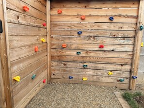 Eine Holzkletterwand mit farbig markierten Griffen.