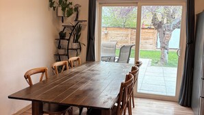 A dining area with a wooden table and chairs, a potted plant, and a view of the backyard through a sliding glass door. - Cozy 2-bedroom house in tranquil Prescott Valley with AC (Prescott Valley)