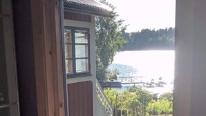 A view from a window overlooking a lake with a dock and a bridge. - 4 Star Holiday Home in Eskilstuna (ESKILSTUNA)