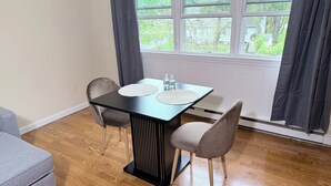 Ein Essbereich mit Tisch, Stühlen und Blick durch ein Fenster.