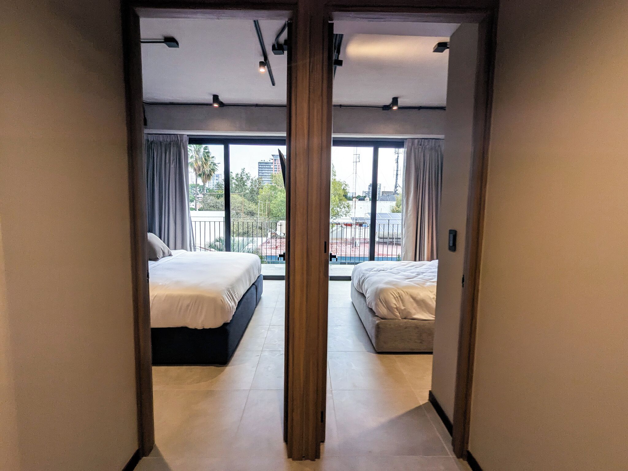 Une chambre d’hôtel avec deux lits, un balcon et une vue sur la ville.