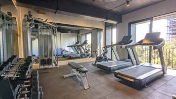 A gym with treadmills, dumbbells, and weight machines.