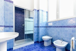 A bathroom with a glass shower enclosure, a toilet, a sink, and a bidet. - Tarsia 42 Suites Napoli (Naples)