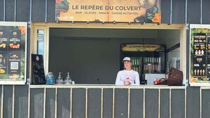 Ein Imbissstand mit einem Schild, auf dem 'LE REPÈRE DU COLVERT' steht, bietet Bar, Eis, Snacks und Aktivitäten an.