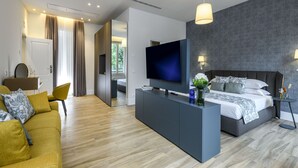 Een moderne hotelkamer met een groot bed, een televisie, een bureau en een bank.