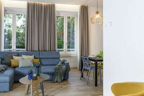 A living room with a sofa, a table, a chair, and a dining table with chairs. - Domus Augustea - Nerone (Roma)
